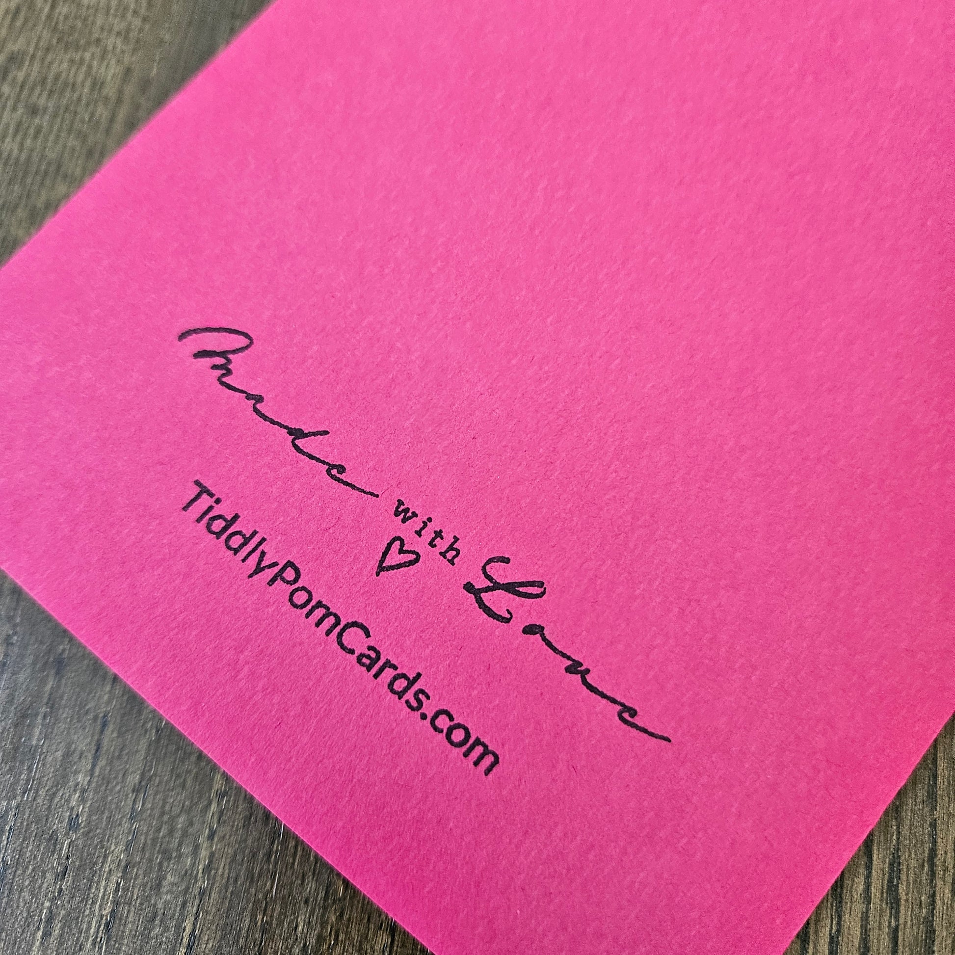 Pink card with 'Made with Love' and 'TiddlyPomCards.com' text on a wooden surface