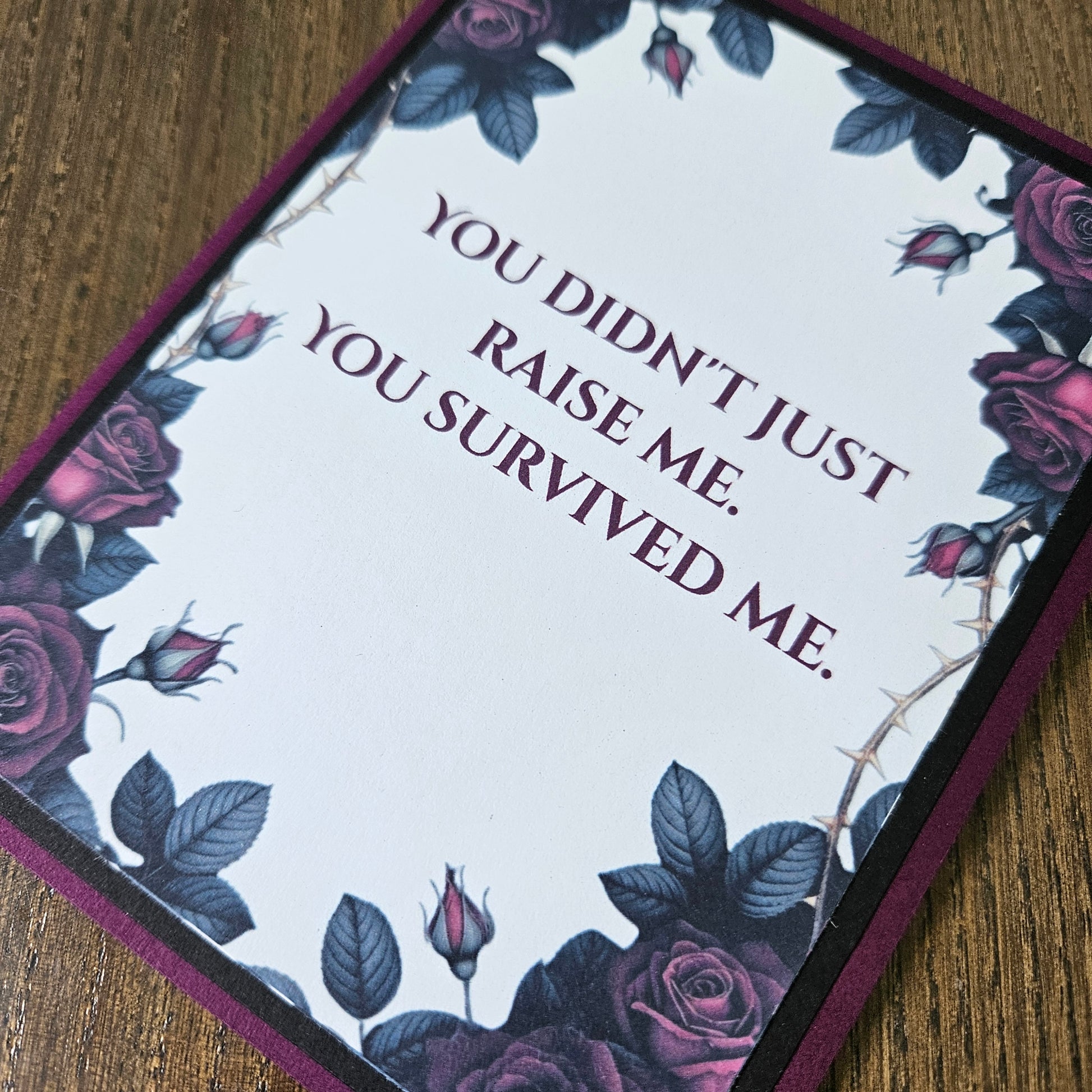 Card with floral design and text on a wooden surface