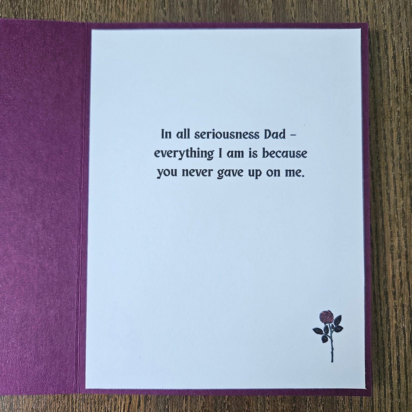 Greeting card with a message to a father on a wooden surface
