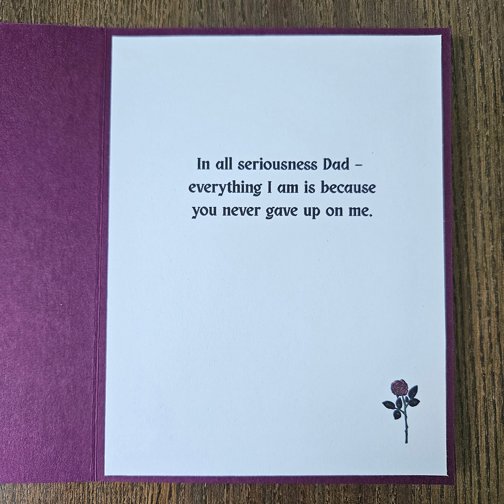 Greeting card with a message to a father on a wooden surface