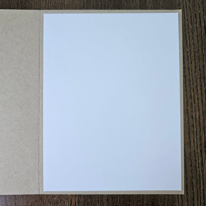 White card with brown border on a wooden surface