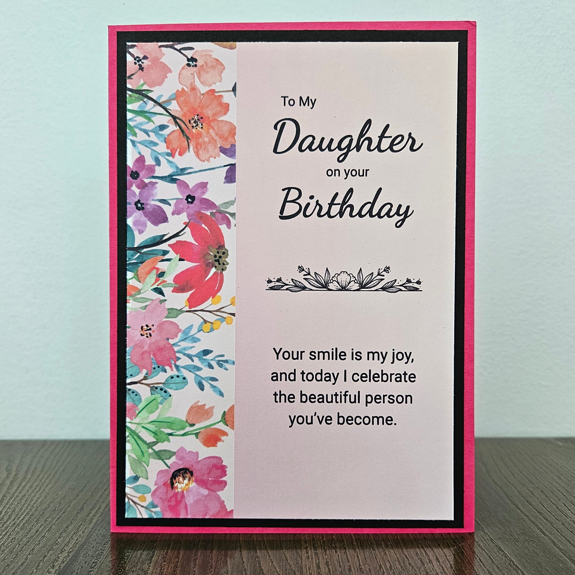 a handmade 5x7 birthday card featuring a vibrant watercolor floral split panel design and printed heartfelt sentiments, finished with a crisp black mat and bright pink cardstock frame. Tiddly Pom Cards
