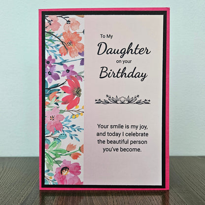 a handmade 5x7 birthday card featuring a vibrant watercolor floral split panel design and printed heartfelt sentiments, finished with a crisp black mat and bright pink cardstock frame. Tiddly Pom Cards