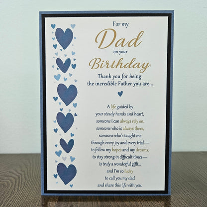 Front of a handmade 5x7 birthday card for Dad featuring a vertical border of stenciled blue hearts on the left and a gold and blue printed poem on a white panel, layered with a black border and a blue card base.