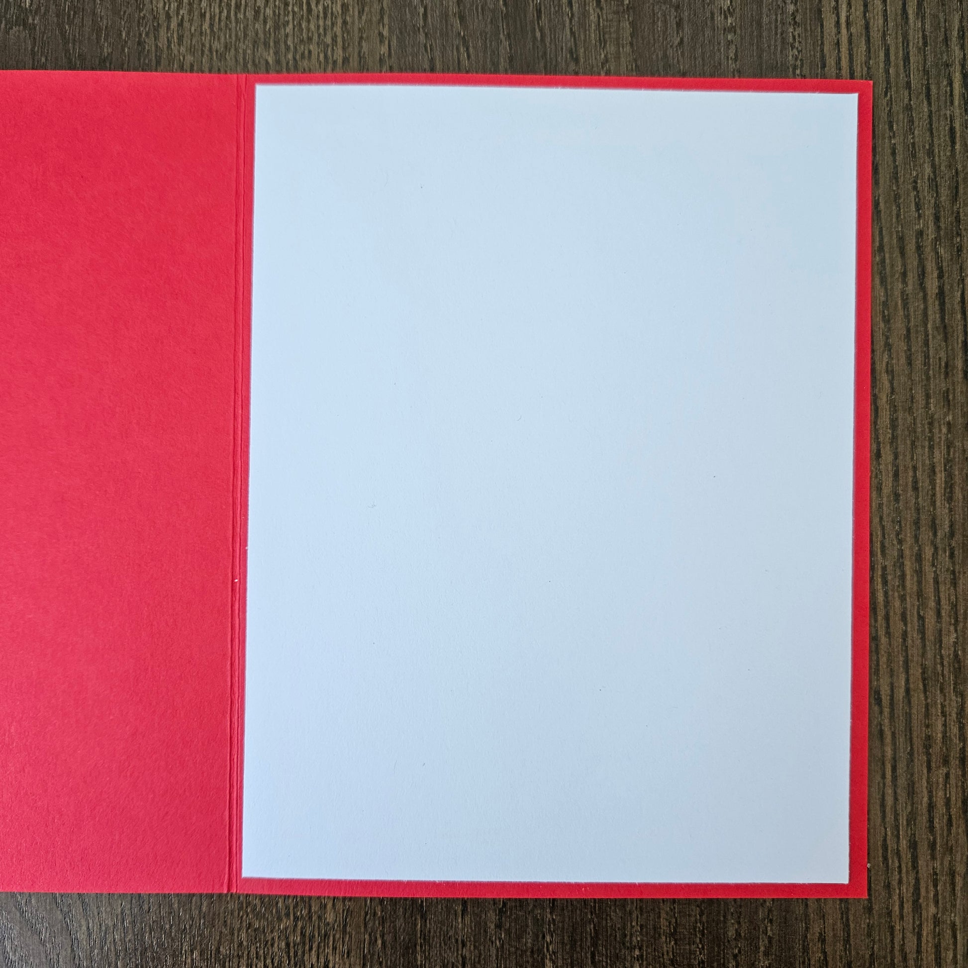 handmade A2 birthday card featuring a classic black ink storybook sketch illustration of Winnie the Pooh wearing a striped party hat while sitting with a wrapped gift box and a balloon, printed with the sentiment Happy Birthday!, finished with a stitched edge border, black mat, and red cardstock