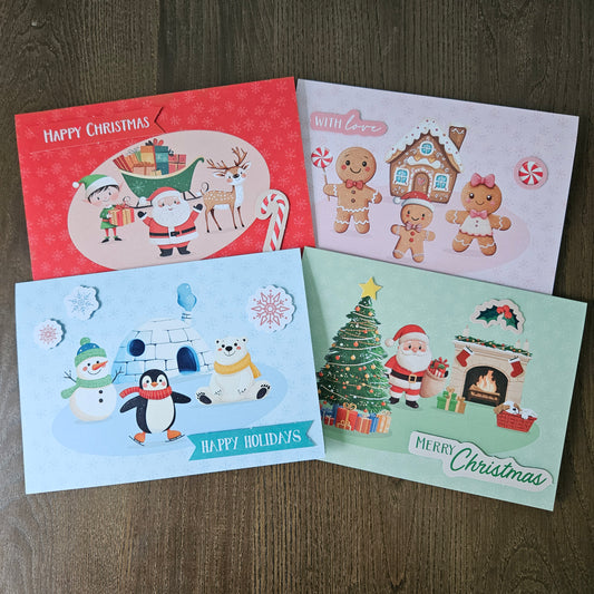 Four Christmas greeting cards arranged on a dark wood surface. The cards feature festive illustrations including Santa Claus, gingerbread people, a snowman, a polar bear, a Christmas tree, and holiday scenes, with text such as 'Happy Christmas,' 'With Love,' and 'Merry Christmas.