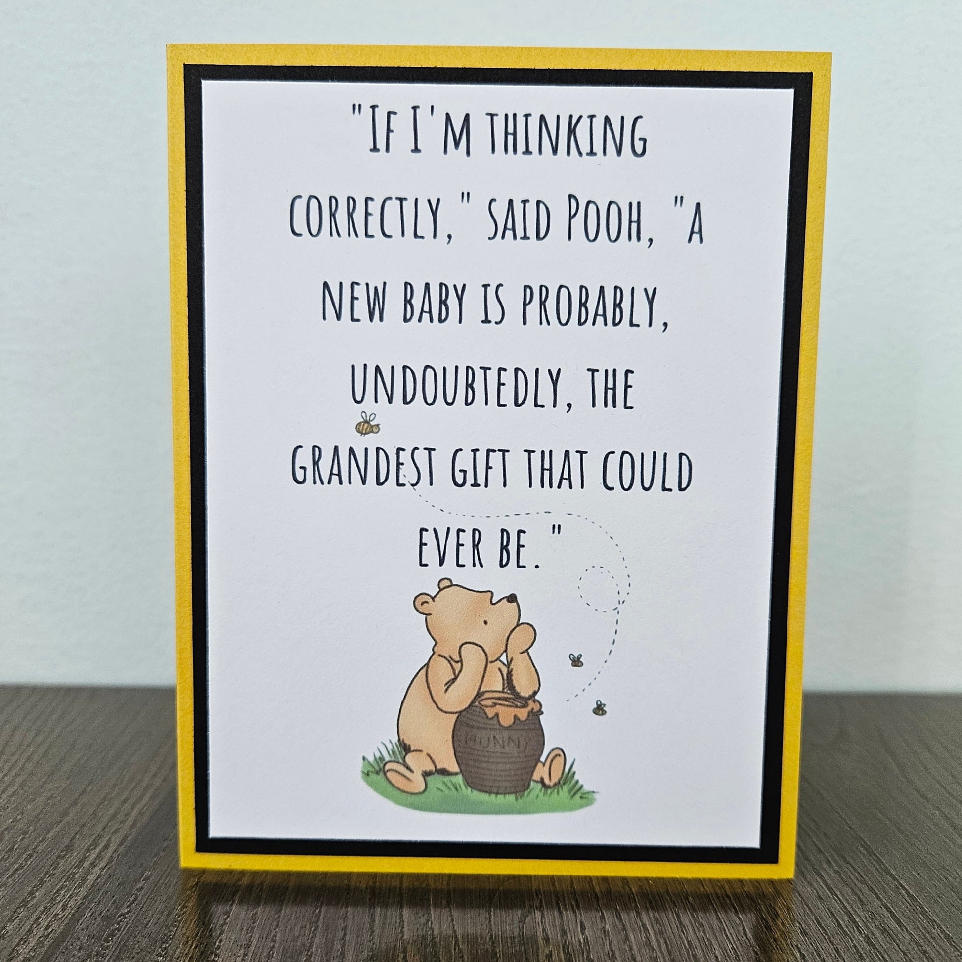 handmade A2 Winnie the Pooh new baby card featuring a classic illustration of Pooh Bear alongside a vintage hunny pot on a layered cardstock panel framed with soft accent matting.
