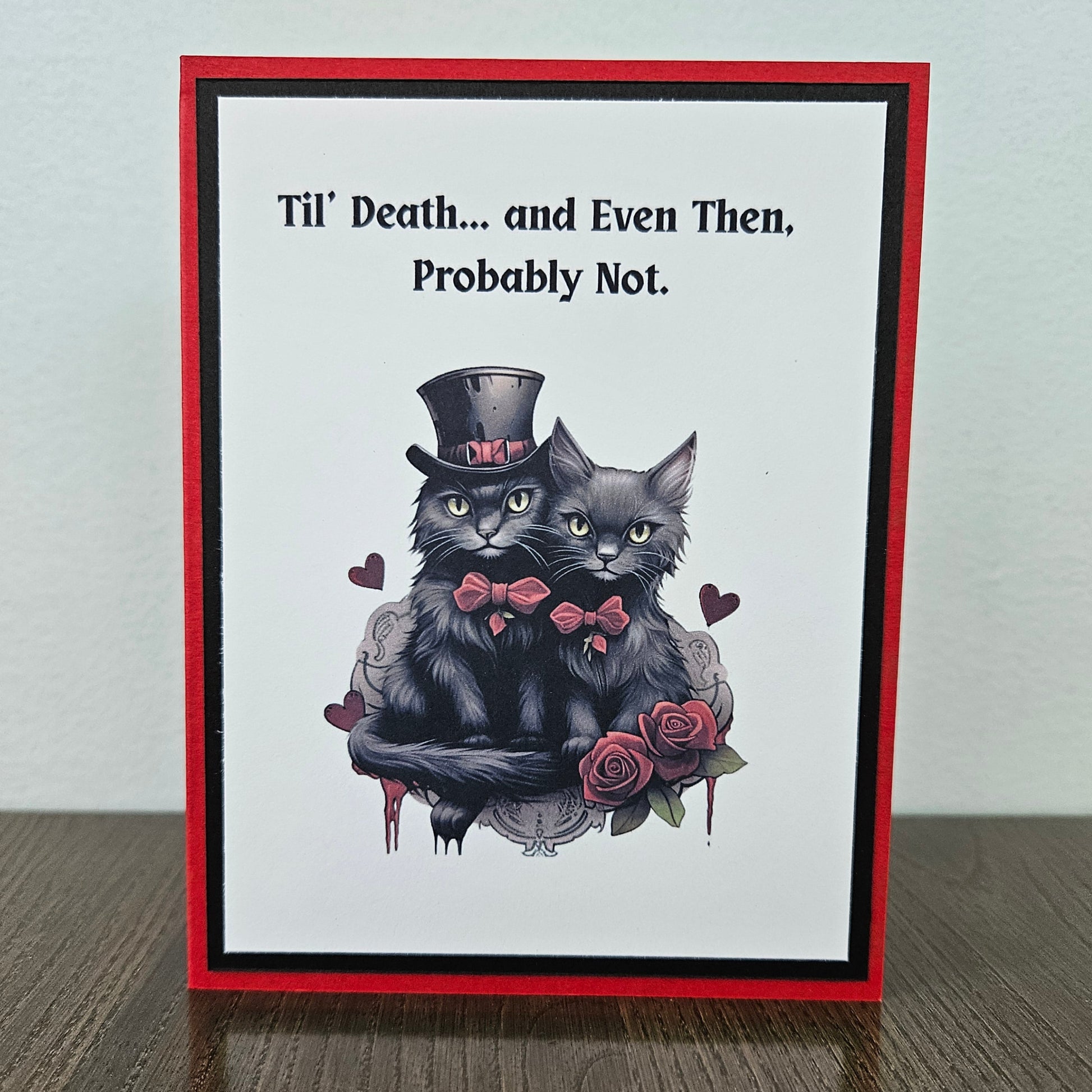Front of a handmade Gothic Valentine's Day card featuring an illustration of two black cats with a bold Til Death banner accent framed in layered dark cardstock.