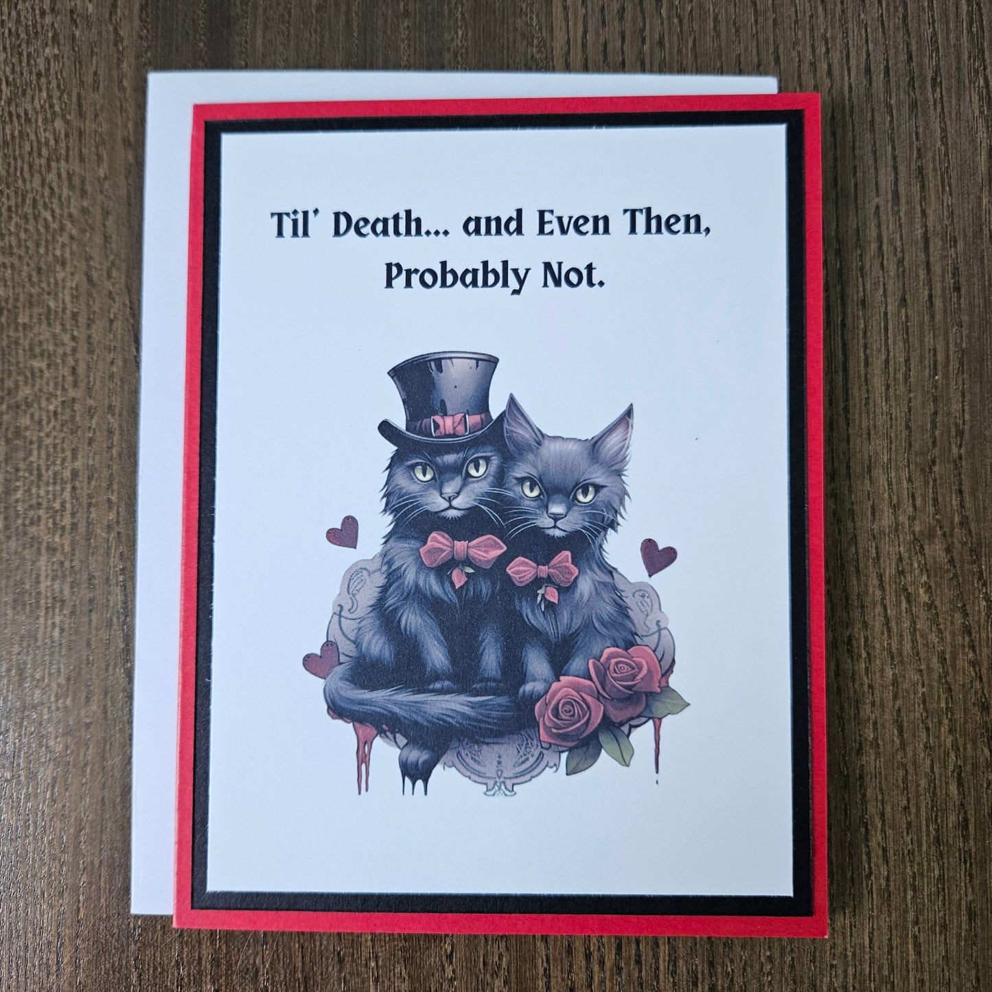 A square greeting card with a white center, red and black border, and an illustration of three gray cats wearing pink bowties and a top hat, surrounded by pink roses. The left side features the text 'Til' Death.