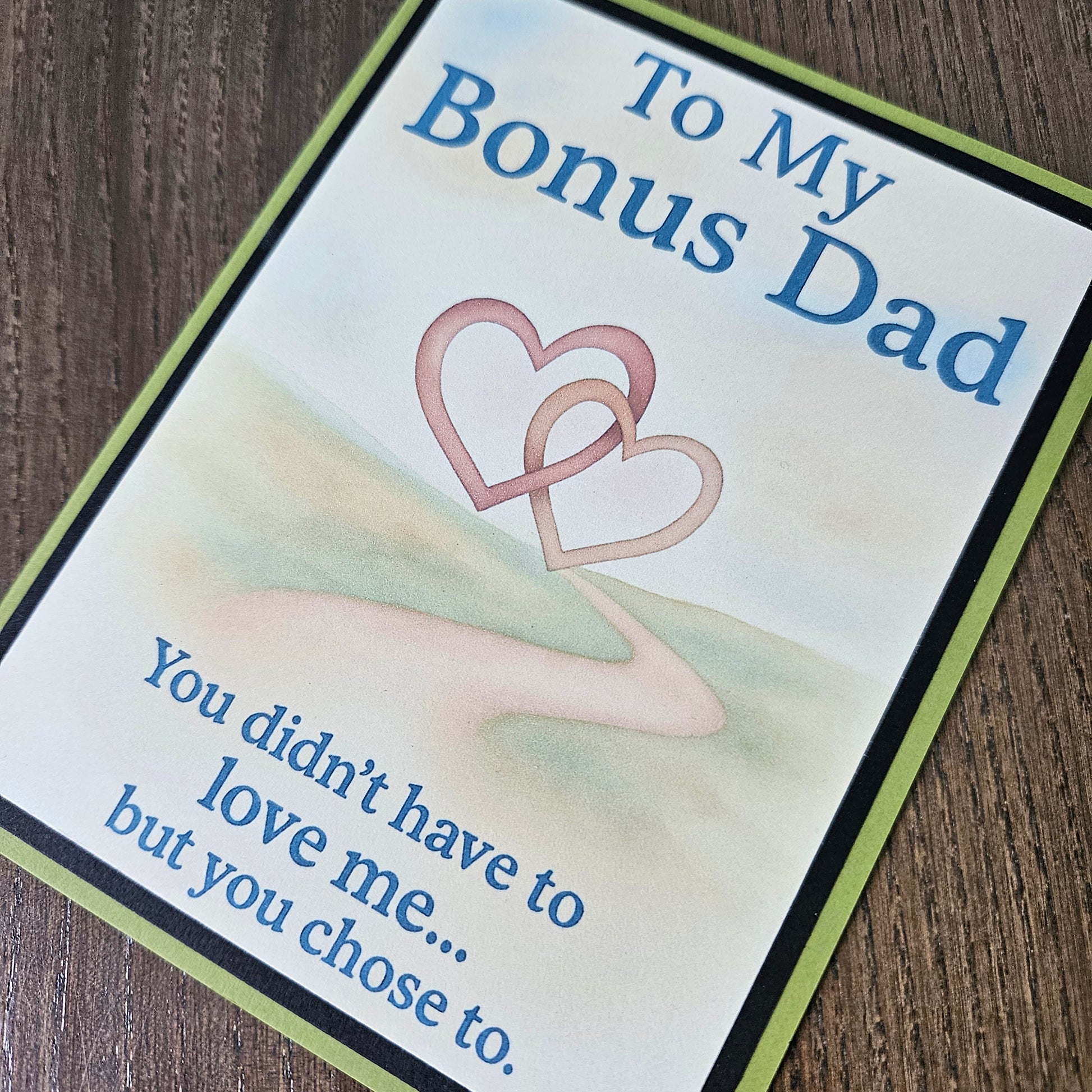 A square greeting card with a light cream background, featuring the text 'To My Bonus Dad' and 'You didn't have to love me.