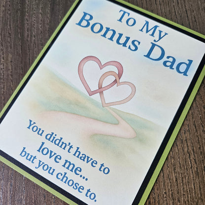 A square greeting card with a light cream background, featuring the text 'To My Bonus Dad' and 'You didn't have to love me.