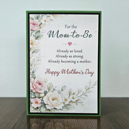 Front of a handmade A2 First Mother's Day card for an expecting mom featuring cream and pink roses framed by green and black borders with text reading To the Mom to Be Happy First Mother's Day.
