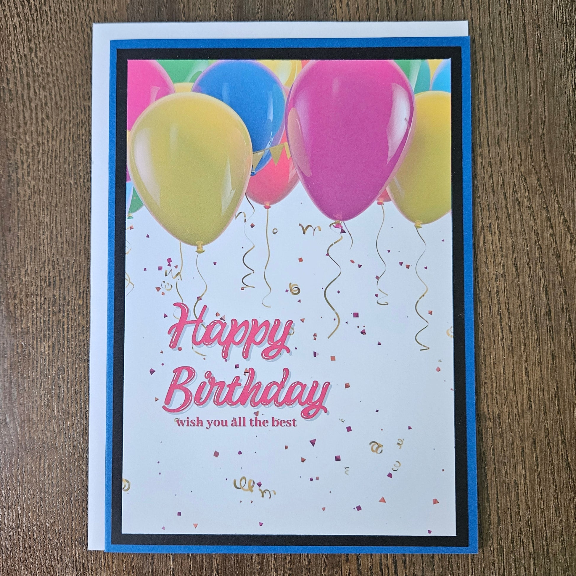 Front of a handmade A2 neutral birthday card featuring colorful balloons and gold confetti framed with layered borders and text reading Happy Birthday.