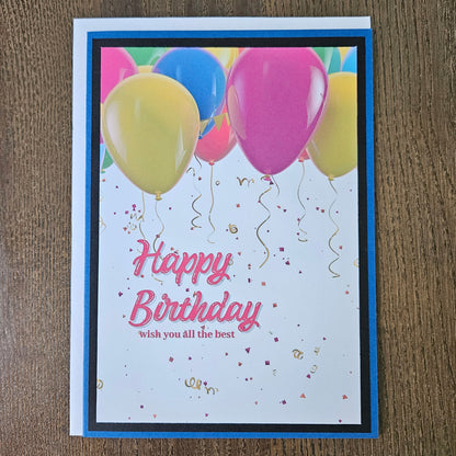 Front of a handmade A2 neutral birthday card featuring colorful balloons and gold confetti framed with layered borders and text reading Happy Birthday.