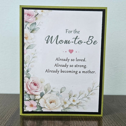 A handmade greeting card with a floral design and the text 'For the Mom-to-Be Already so loved. Already so strong.