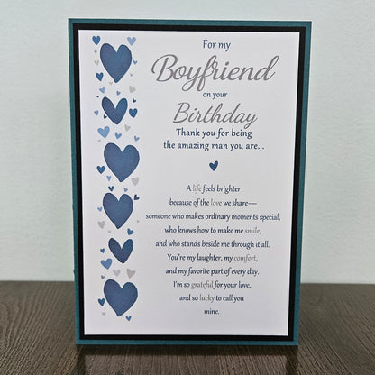 Front of a handmade 5x7 birthday card for boyfriend featuring a vertical row of watercolor blue hearts framed in black and teal with a detailed romantic birthday poem.