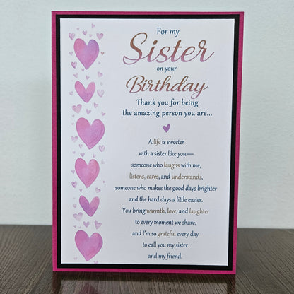 Front of a handmade 5x7 birthday card for sister featuring a vertical row of watercolor pink hearts framed in black and magenta with a detailed birthday poem.