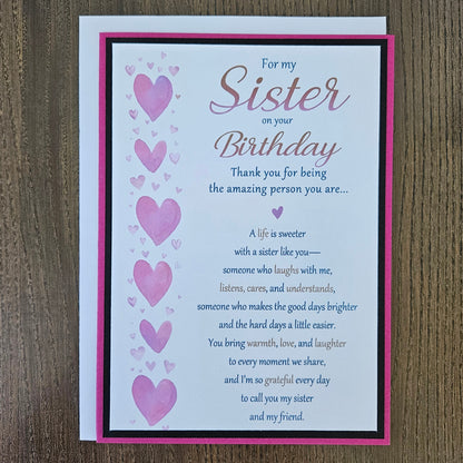 Front of a handmade 5x7 birthday card for sister featuring a vertical row of watercolor pink hearts framed in black and magenta with a detailed birthday poem.