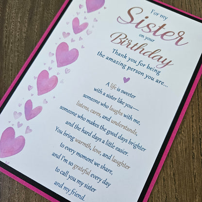 Front of a handmade 5x7 birthday card for sister featuring a vertical row of watercolor pink hearts framed in black and magenta with a detailed birthday poem.