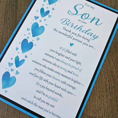 Front of a handmade 5x7 birthday card for son featuring a vertical row of watercolor blue hearts framed in black and blue with a detailed birthday poem.