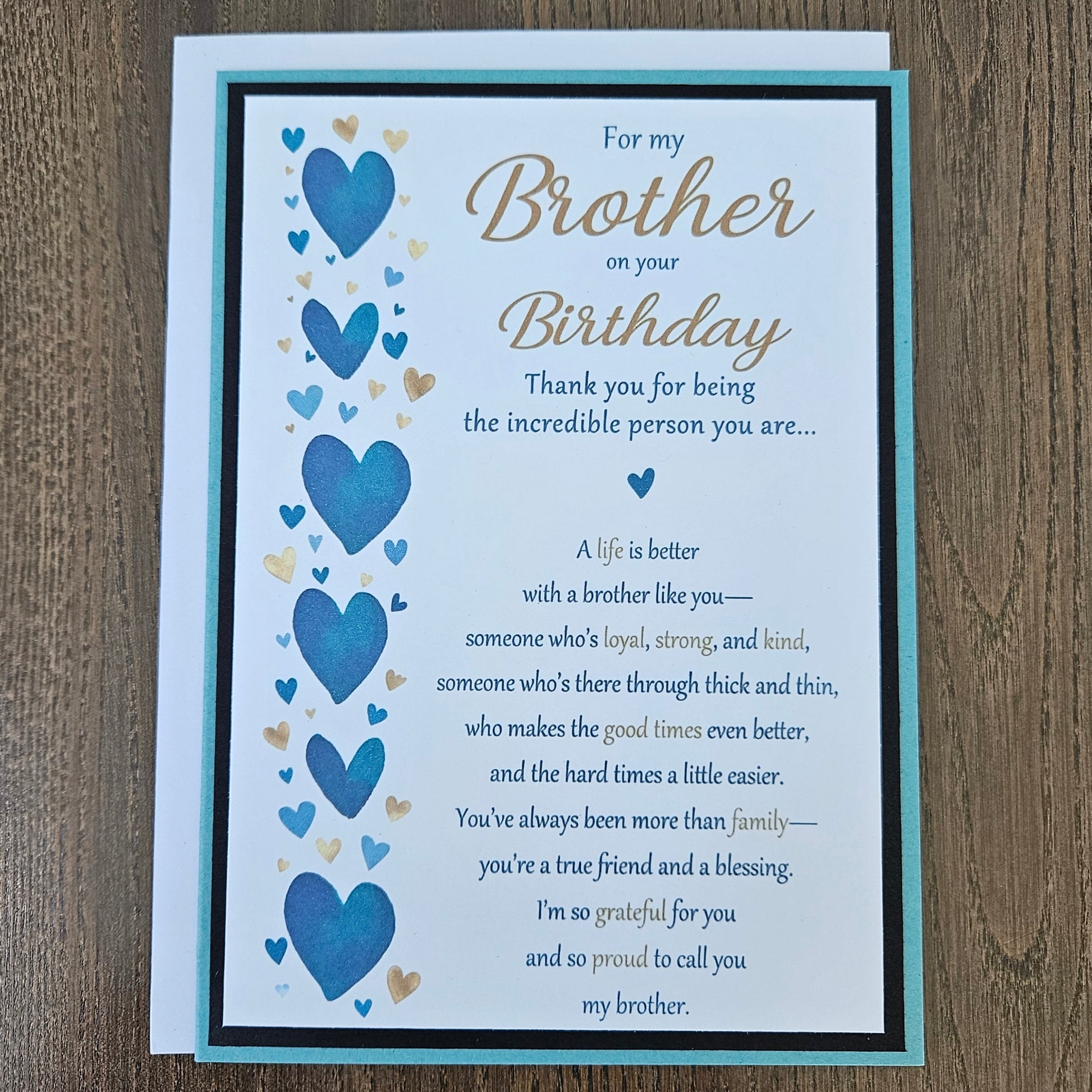 Front of a handmade 5x7 birthday card for brother featuring a vertical row of watercolor blue and gold hearts framed in black and teal with a detailed birthday poem.