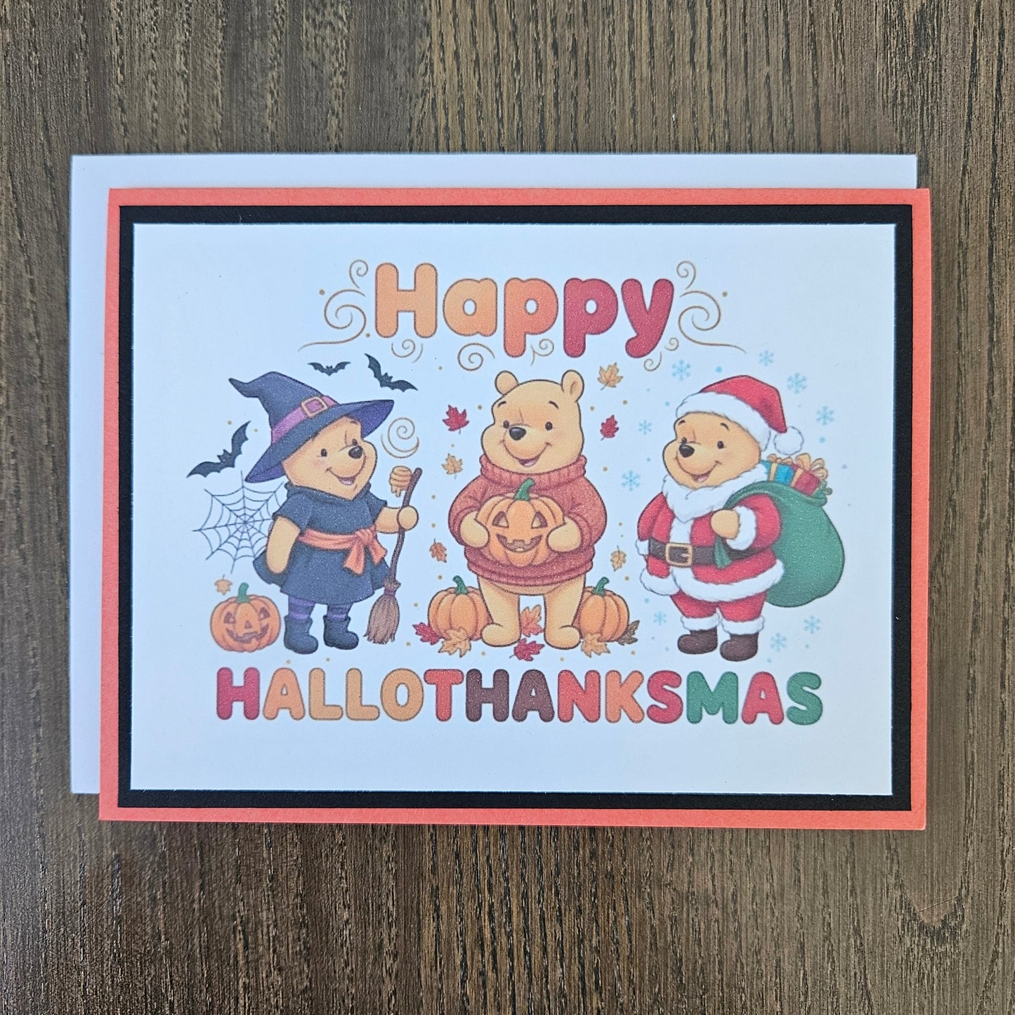 A square Halloween greeting card featuring Winnie the Pooh and friends in costumes, with the text 'Happy HALLOTHANKSMAS' on a light wood background.