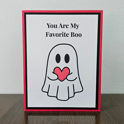 Front of a handmade A2 love card featuring a cute ghost holding a red heart framed in black and red with text reading You Are My Favorite Boo.