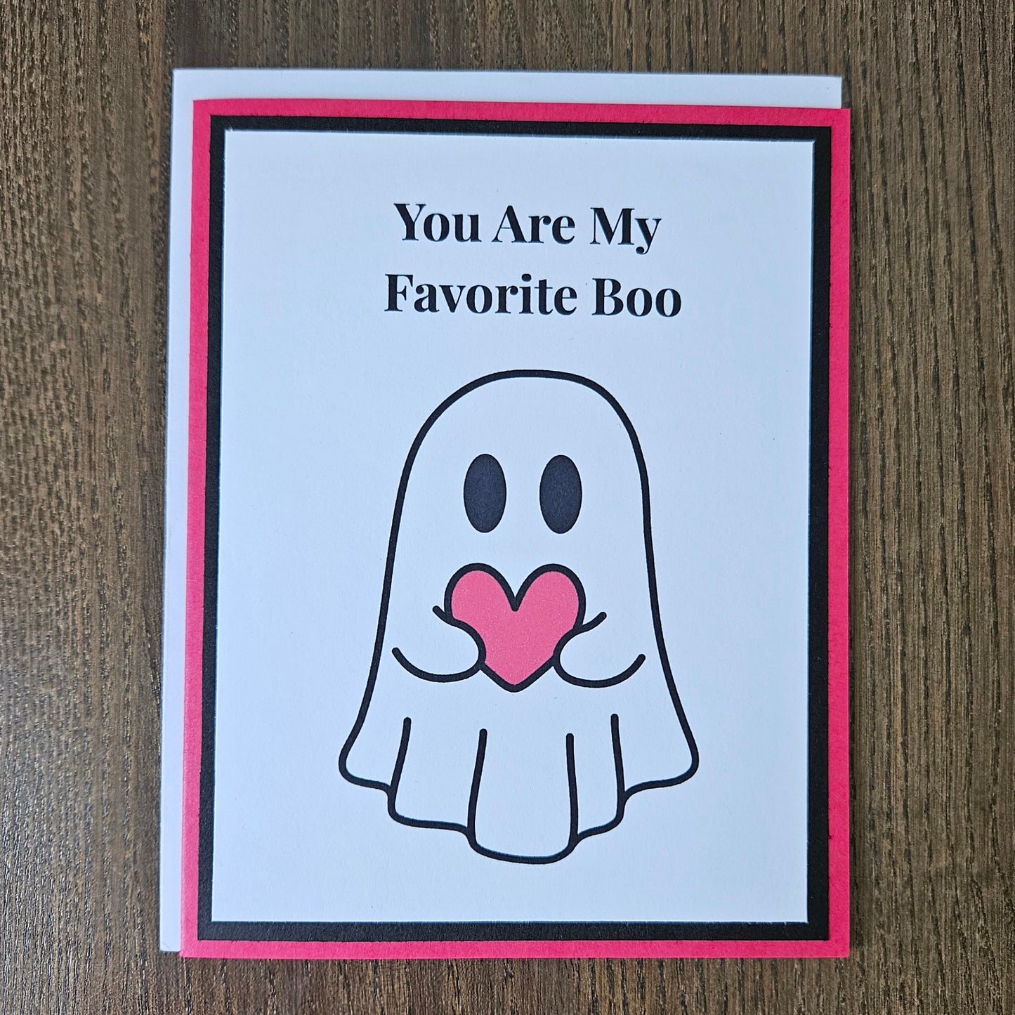 Front of a handmade A2 love card featuring a cute ghost holding a red heart framed in black and red with text reading You Are My Favorite Boo.