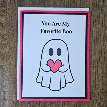 Front of a handmade A2 love card featuring a cute ghost holding a red heart framed in black and red with text reading You Are My Favorite Boo.