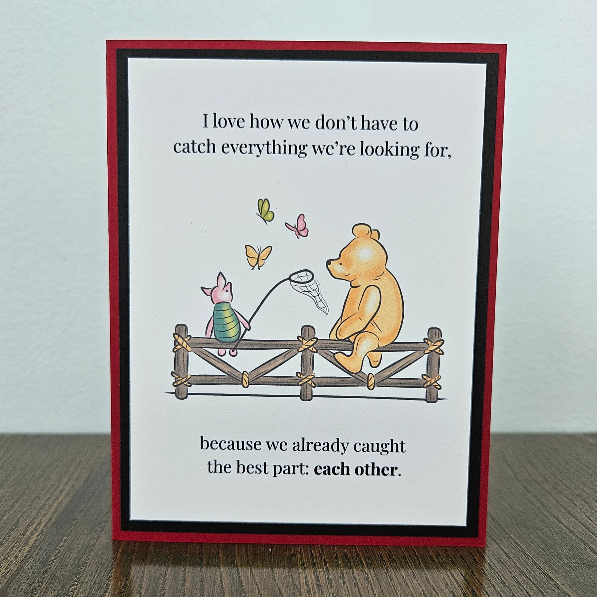 Handmade Winnie the Pooh friendship card featuring a classic storybook illustration of Pooh Bear and Piglet sitting together on a rustic wooden fence watching butterflies, finished with layered cardstock frames.