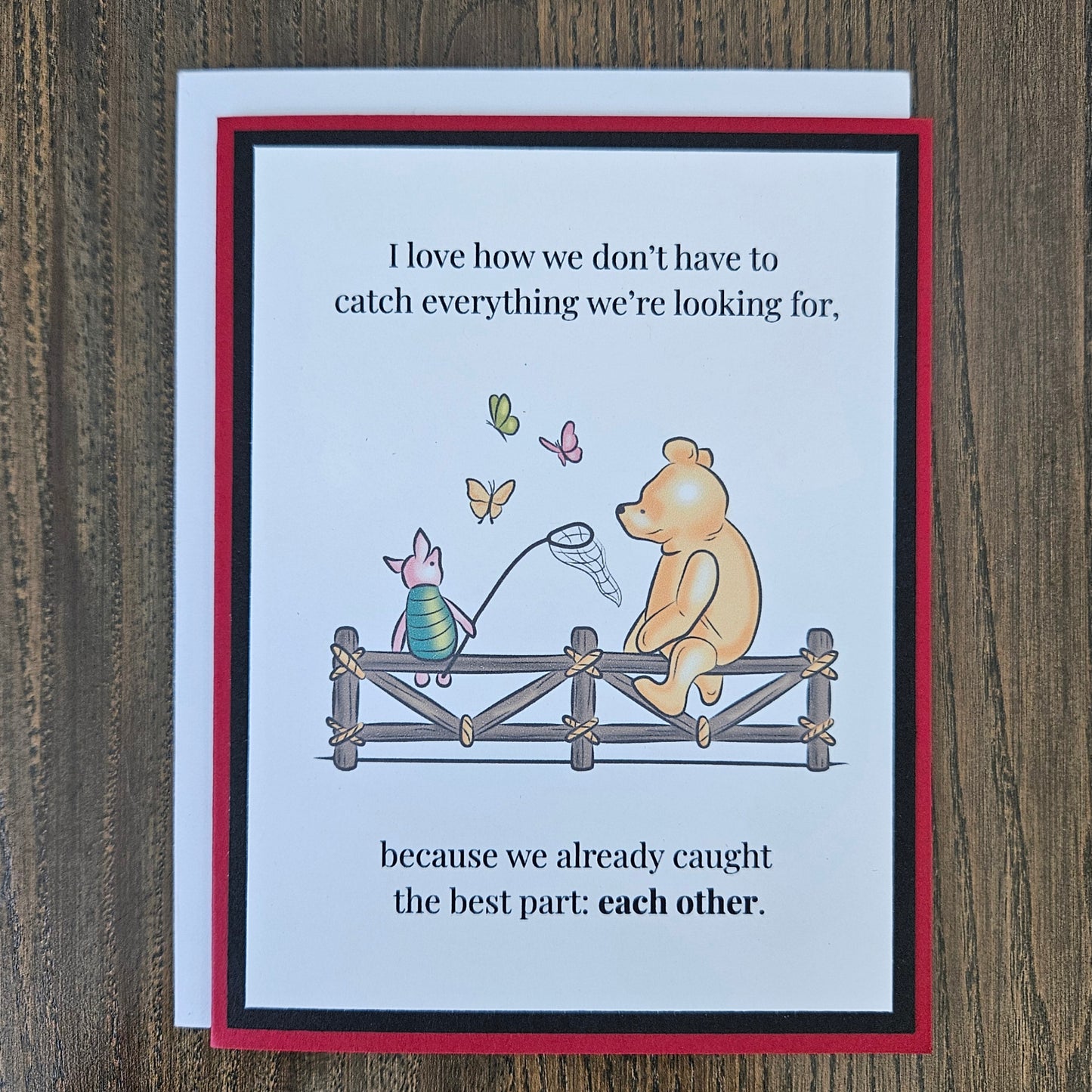 Handmade Winnie the Pooh friendship card featuring a classic storybook illustration of Pooh Bear and Piglet sitting together on a rustic wooden fence watching butterflies, finished with layered cardstock frames.
