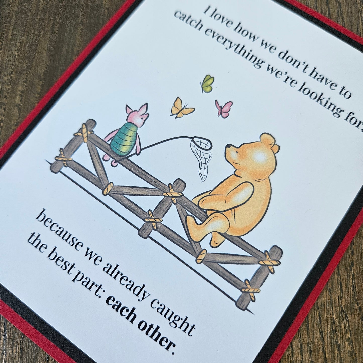 Handmade Winnie the Pooh friendship card featuring a classic storybook illustration of Pooh Bear and Piglet sitting together on a rustic wooden fence watching butterflies, finished with layered cardstock frames.