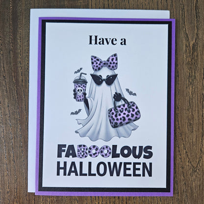 Front of a handmade A2 Halloween card featuring a layered purple and black border around a fashionable ghost wearing a purple leopard bow and sunglasses, holding an iced coffee and purse, with text reading Have a FABOOLOUS HALLOWEEN.
