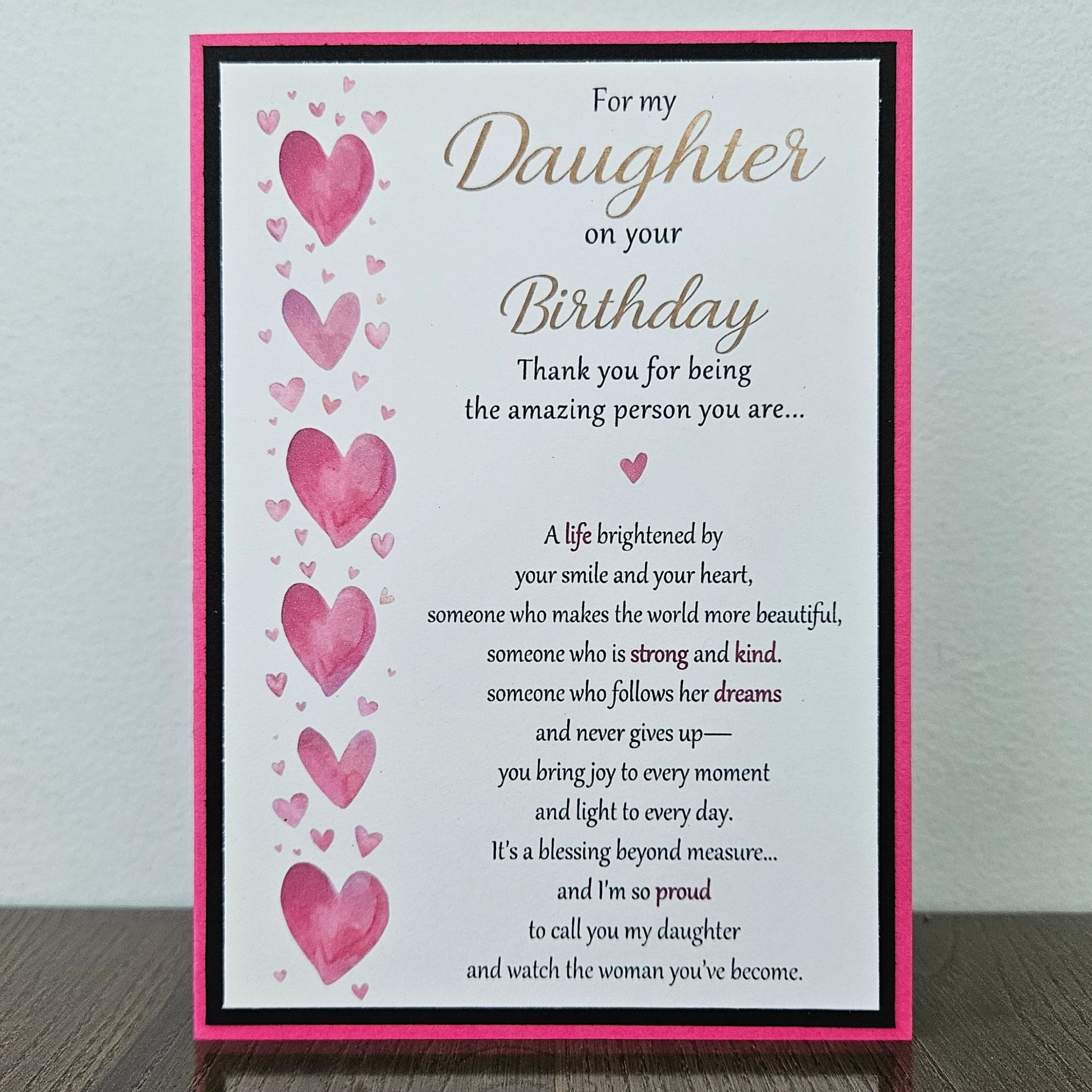 Front and inside view of a handmade 5x7 birthday card for daughter featuring pink watercolor hearts, bold black and hot pink borders, and printed sentimental verses.