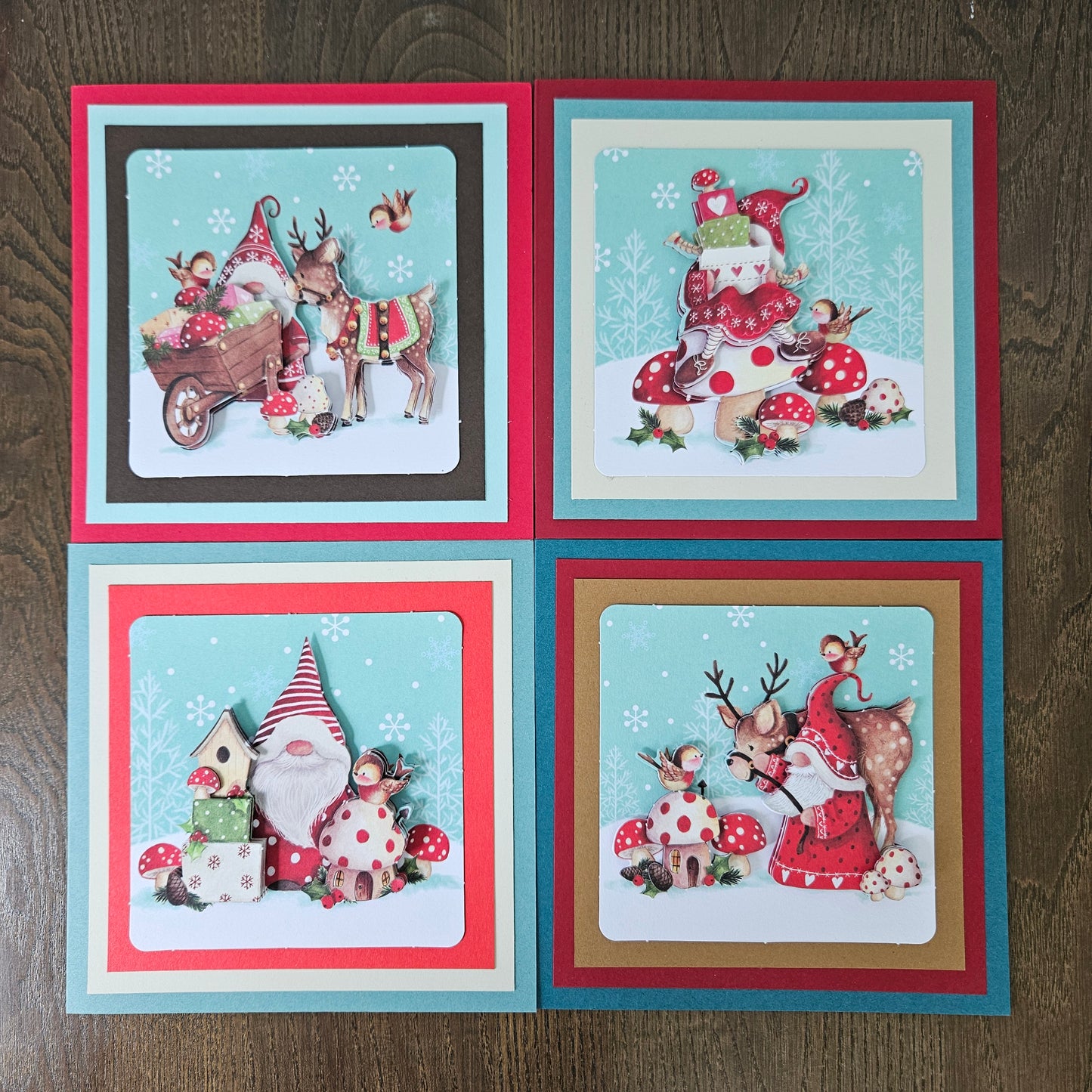 Front and inside views of a 4-card set of handmade 5.5x5.5 square Christmas cards featuring 3D decoupage gnomes, reindeer, birds, and toadstools.