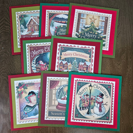 A set of eight Christmas greeting cards arranged on a dark wood surface. Each card features a colorful winter holiday illustration with layered red, green, and white borders, including scenes of snow-covered houses, a Christmas tree, a snowman, a snow globe, and festive text such as 'Merry Christmas' and 'Season's Greetings'.