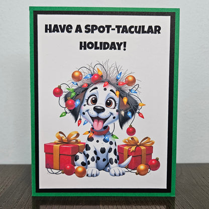 Front of a funny handmade A2 Christmas card featuring a Dalmatian puppy tangled in Christmas lights reading Have A Spot-Tacular Holiday.