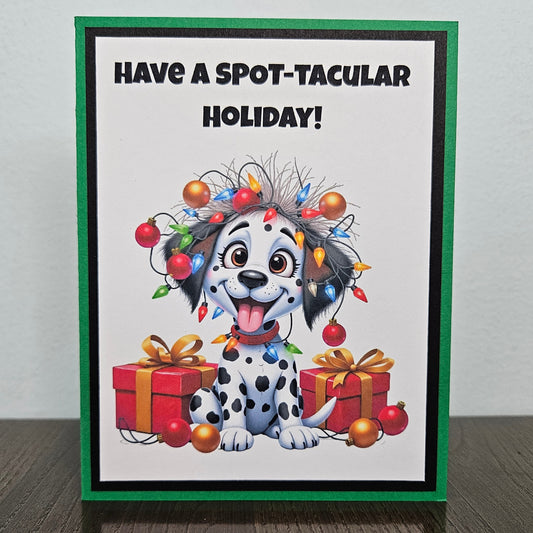 Front of a funny handmade A2 Christmas card featuring a Dalmatian puppy tangled in Christmas lights reading Have A Spot-Tacular Holiday.