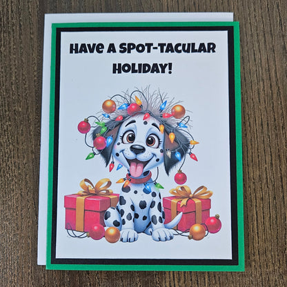 Front of a funny handmade A2 Christmas card featuring a Dalmatian puppy tangled in Christmas lights reading Have A Spot-Tacular Holiday.