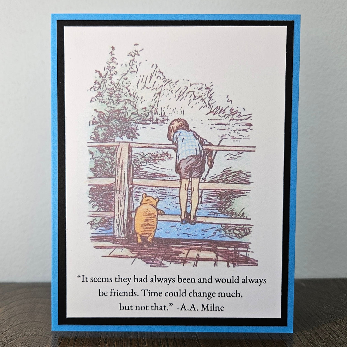A square greeting card featuring a Winnie the Pooh illustration of Pooh and Tigger looking at water, with a quote from A.A.