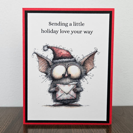 Handmade Christmas card with Santa-hat bat holding envelope and Sending a little holiday love your way message