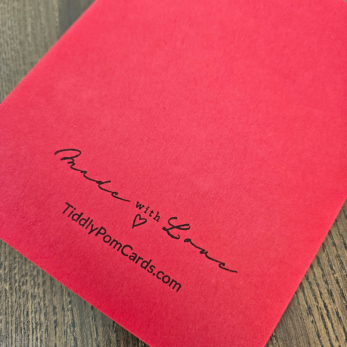 Red back of handmade holiday card with Tiddly Pom Cards branding