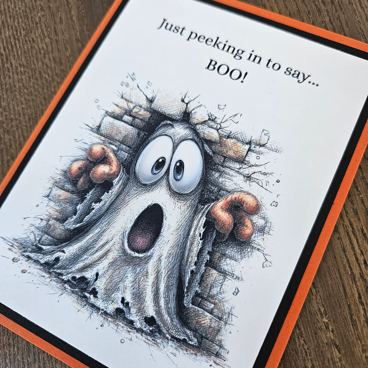 A square greeting card featuring a spooky cartoon ghost peeking through a broken brick wall with the text 'Just peeking in to say.