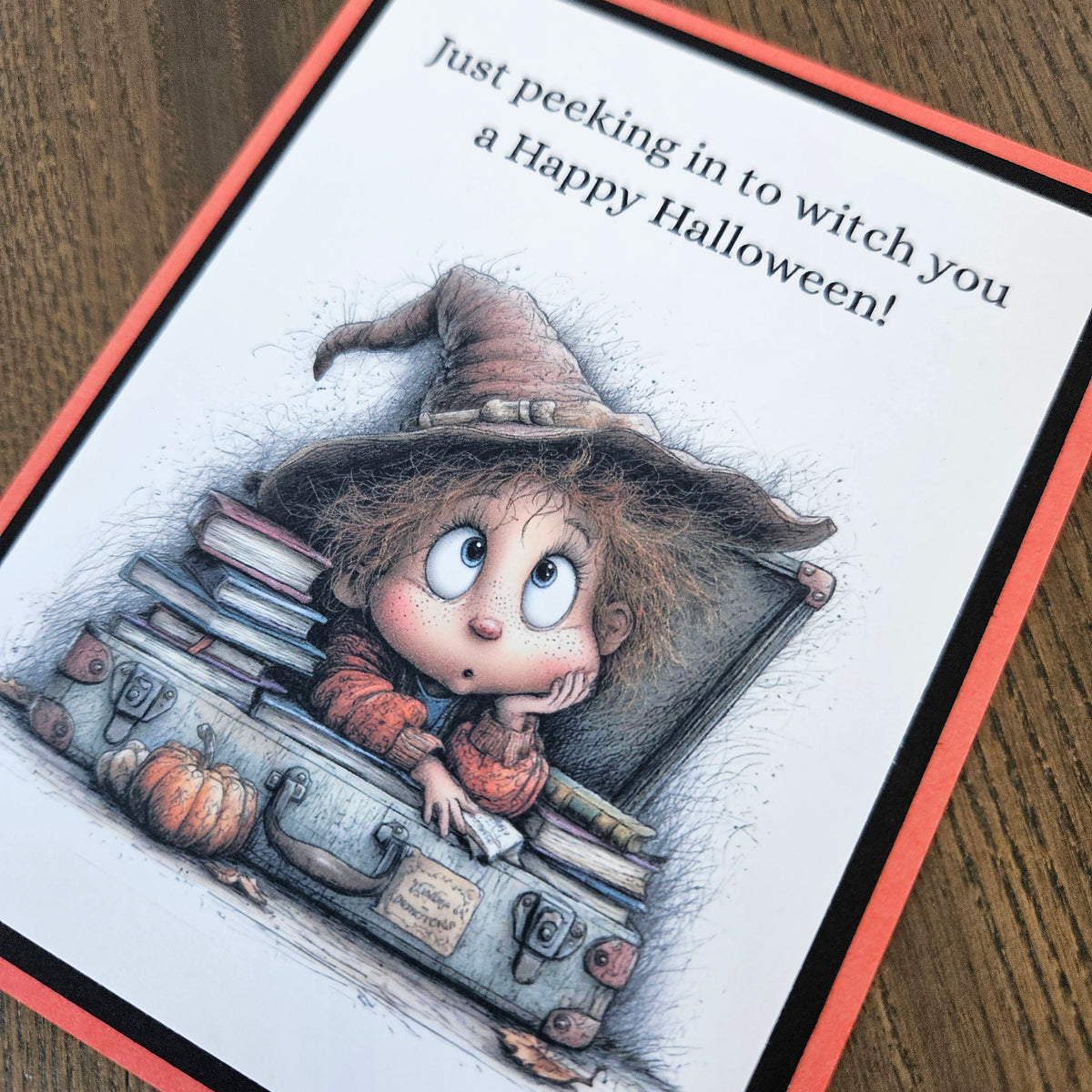 Close-up of whimsical young witch, spellbooks, pumpkin, and Happy Halloween pun sentiment