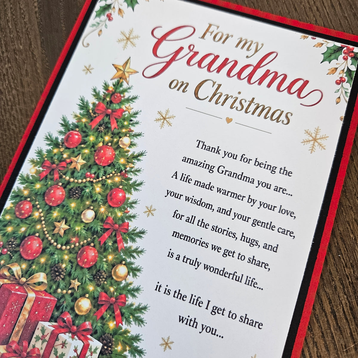 Angled close-up of a 5 x 7 Grandma Christmas card with red border, decorated tree and printed poem.