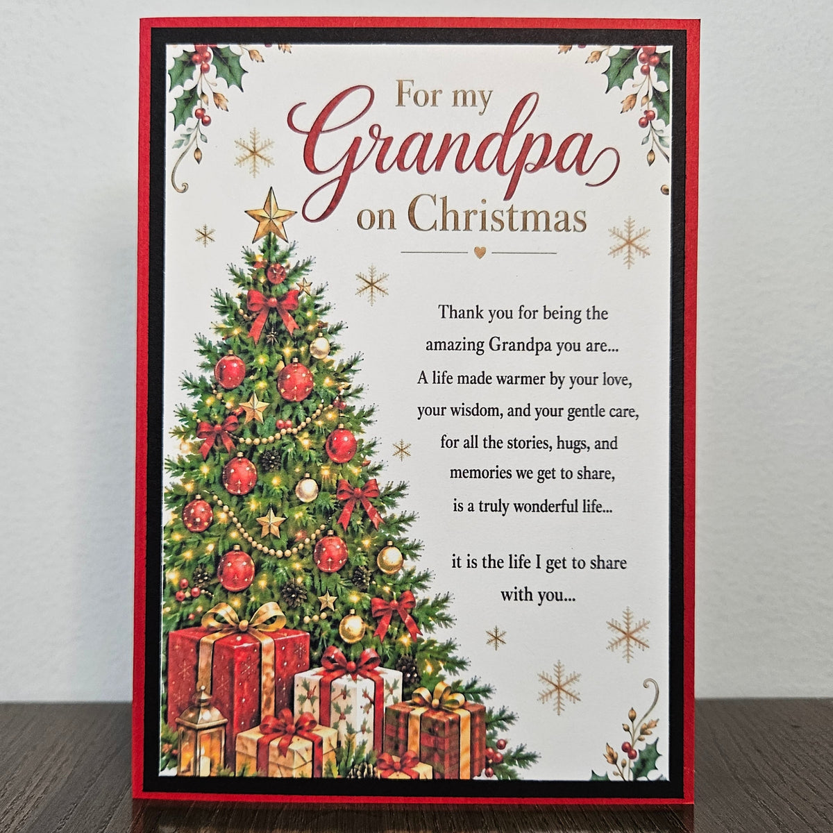 Handmade Grandpa Christmas card standing upright, with a decorated tree, gifts, snowflakes, and a heartfelt front message