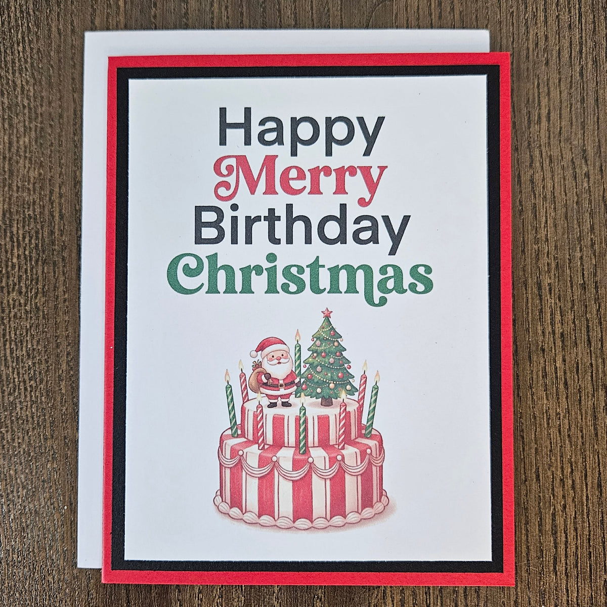 Handmade Christmas birthday card showing Santa on a birthday cake beside a decorated tree, with a white envelope behind it.