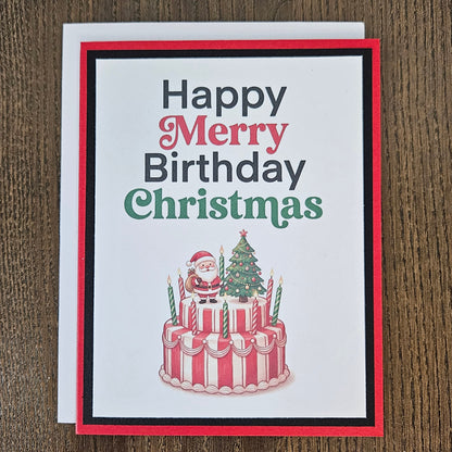 Handmade Christmas birthday card showing Santa on a birthday cake beside a decorated tree, with a white envelope behind it.