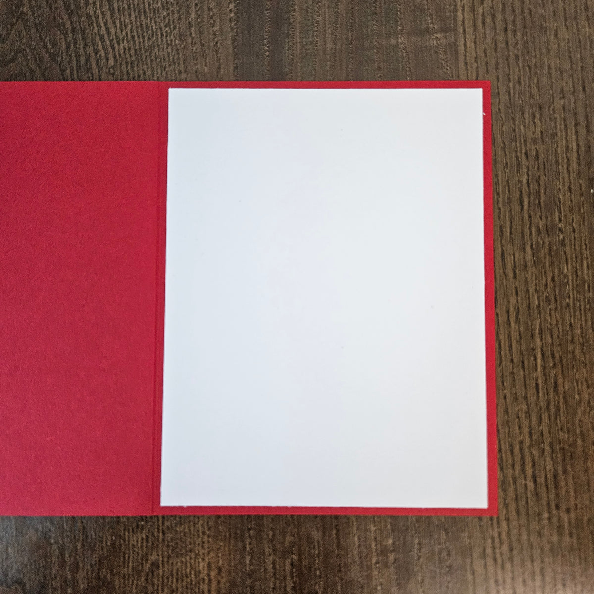 Open red Christmas card with a blank white inside panel for a personal holiday message.