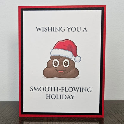 Handmade red and black Christmas card with a smiling poop emoji in a Santa hat and Wishing you a smooth-flowing holiday wording.